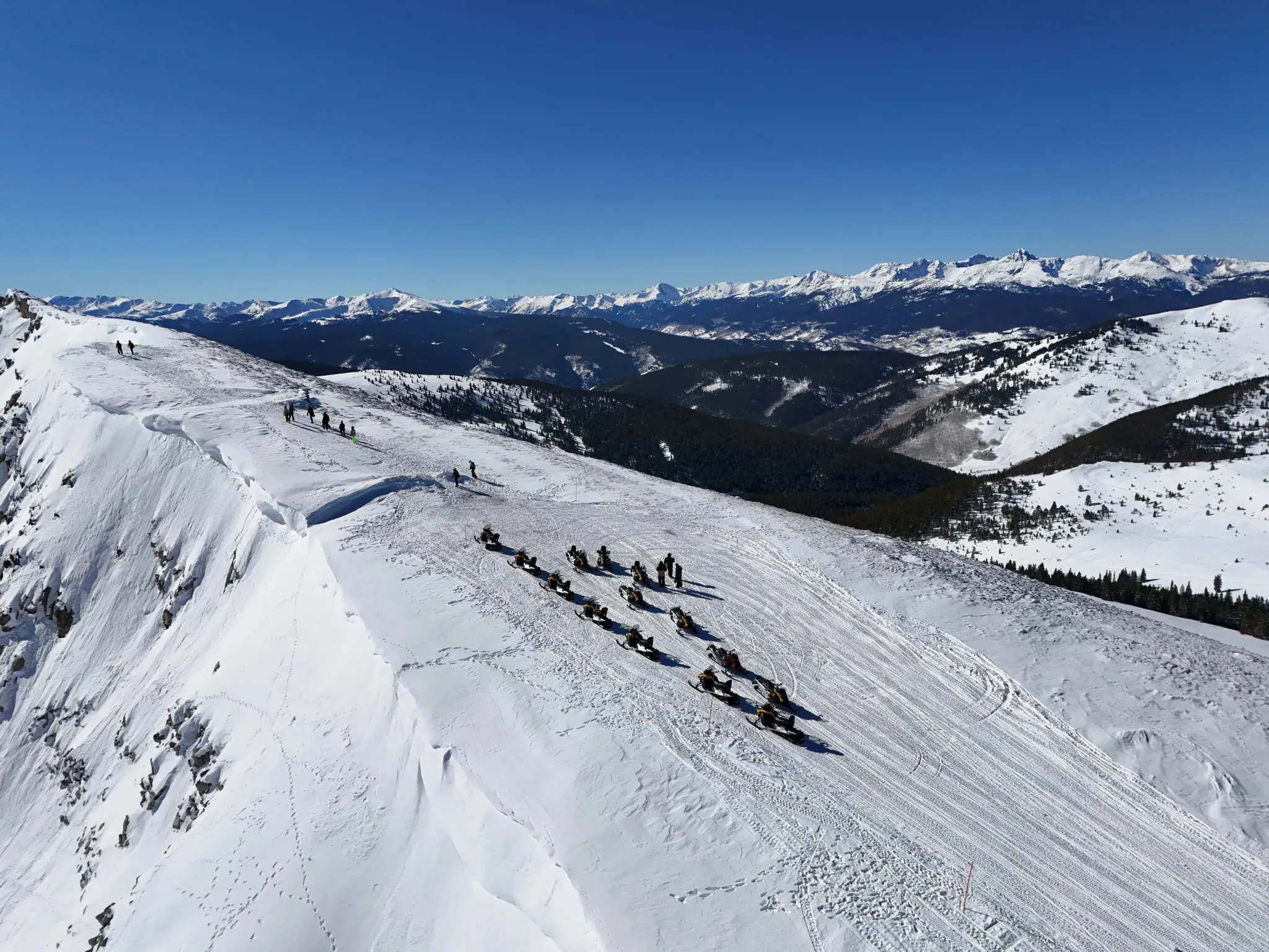 Snowmobile riders on a guided tour near Breckenridge, Colorado with Rocky Mountain views.