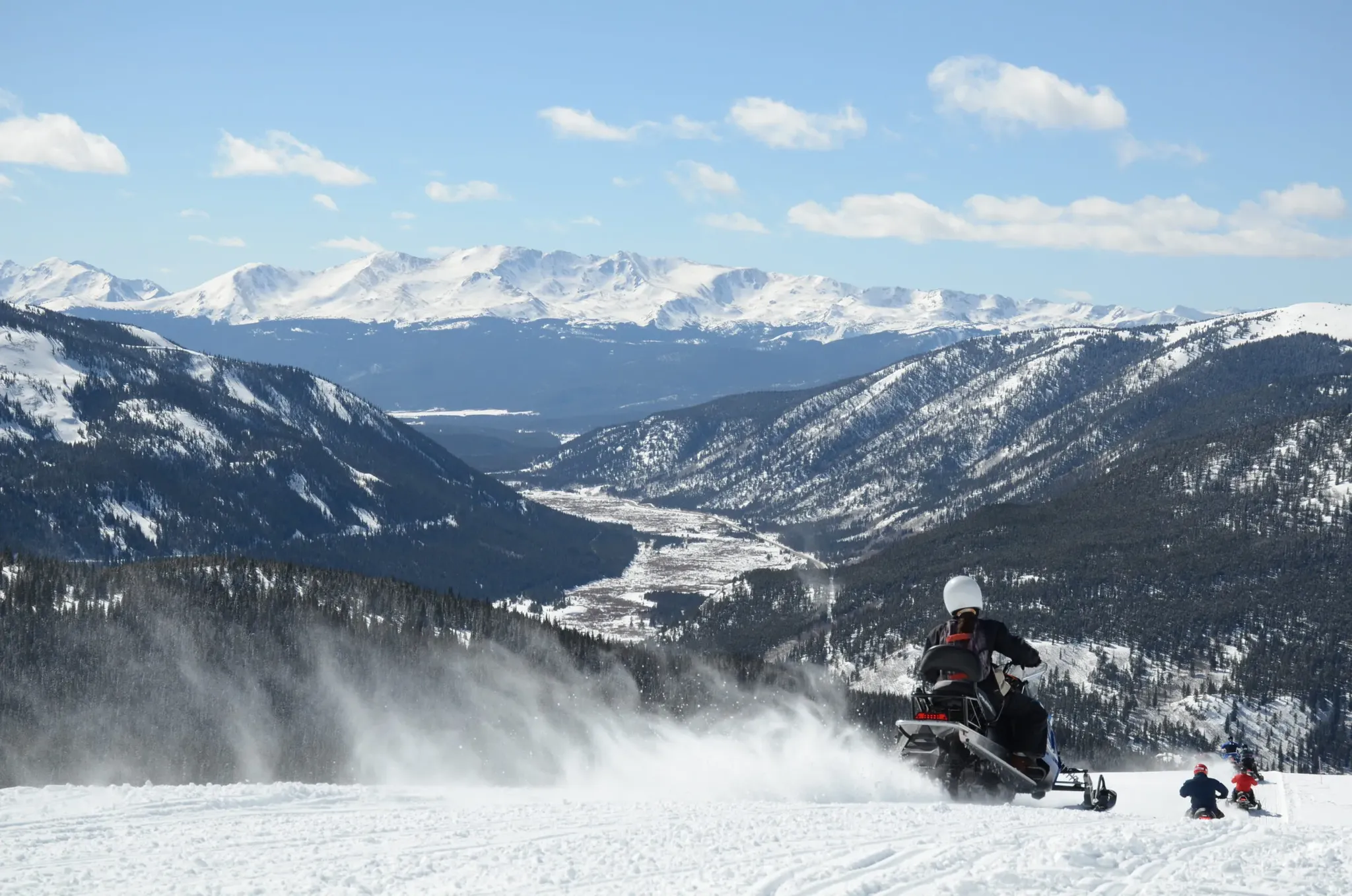 Three riders on a guided Performance snowmobile tour at Fremont Pass near Breckenridge, Colorado.